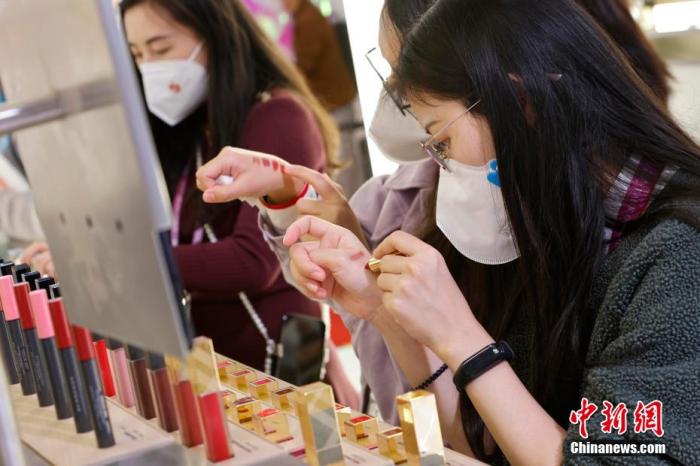 圖為女生正在體驗口紅產(chǎn)品。 殷立勤 攝