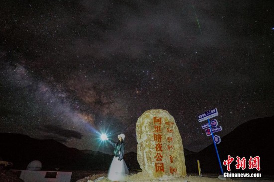 圖為6月20日晚，游客“打卡”西藏阿里暗夜公園，天上是銀河與流星（右上角）。曹枝清 攝