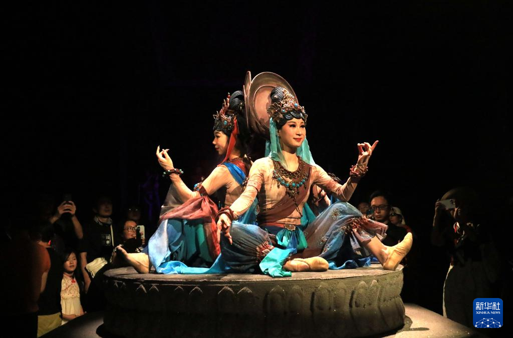 8月5日晚,游客在甘肅省敦煌市觀看大型洞窟式沉浸體驗劇《樂動敦煌》。 新華社發(fā)(張曉亮 攝)